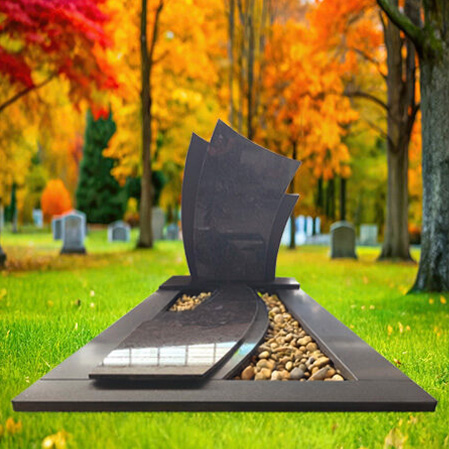 "Polished dark grey granite upright headstone with curved top, matching ledger slab, and decorative white pebble sections on each side"