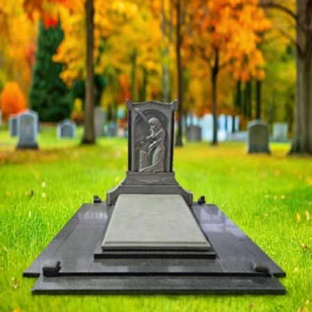 "Polished black granite upright headstone with hand-carved resting angel figure and full-length polished ledger slab in European-style memorial layout."
