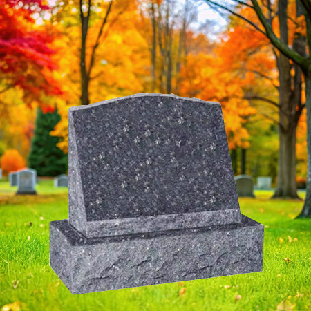 "Grey granite slant upright headstone memorial with polished front face and natural chiseled edge finishes, set on a coordinating granite base in a tranquil autumn setting."