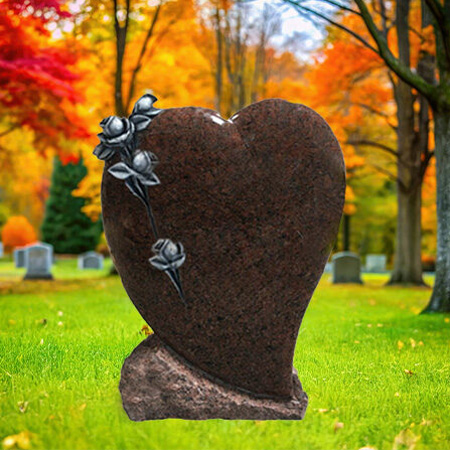 "Red granite upright heart-shaped headstone memorial with cascading rose carvings and chiseled base—symbolizing remembrance and devotion."