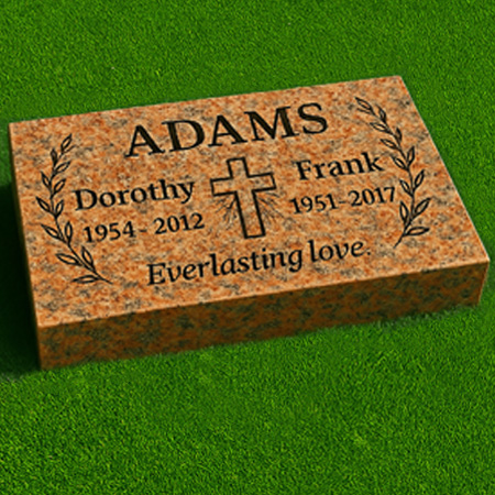 "Red granite pillow flush grass marker with laurel carvings, center cross, companion inscriptions, and heartfelt epitaph."