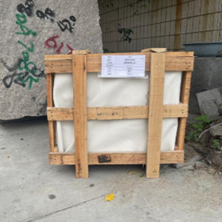 "Large wooden crate with white protective covering and export label, used for shipping ELHASG memorials, sculptures, and stone slabs internationally."