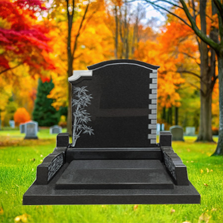 "Black granite upright headstone with bamboo engraving on the left, stepped edge on the right, and platform base with side supports."