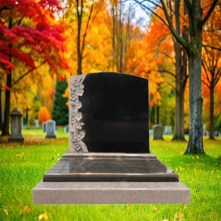 "Polished black granite upright headstone with floral carving on the left side, mounted on a polished granite base."