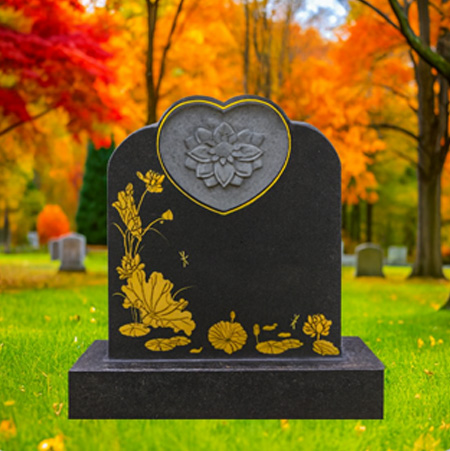 "Polished black granite upright headstone with heart-shaped floral motif, lotus flowers, and dragonfly engraving, mounted on a matching granite base."