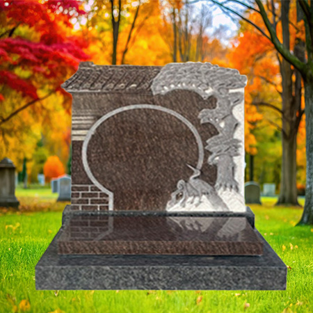 "Polished dark brown granite upright headstone with circular centerpiece, brick border, and engraved tree with bird, set on a rectangular base in an autumn cemetery setting."