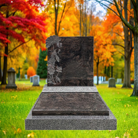 "Polished dark granite upright headstone with floral carving on the left side, mounted on a light granite base."