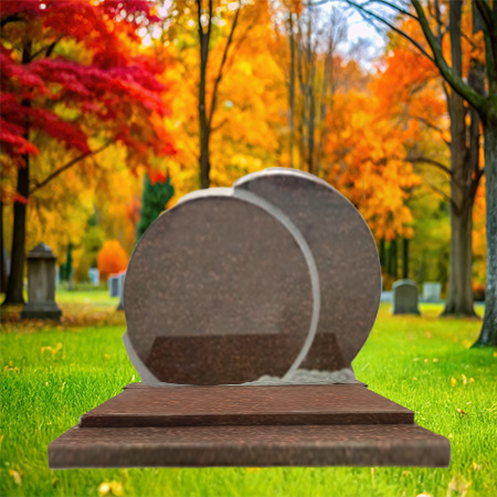 "Polished dark red granite upright headstone with two carved oval shapes, mounted on a multi-tiered granite base."