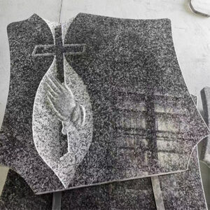 "Polished granite upright headstone with praying hands and cross engraving framed in teardrop shape at Elhasg factory."