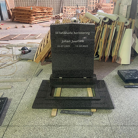 "Polished black granite memorial component mounted on base in Elhasg workshop with technician."
