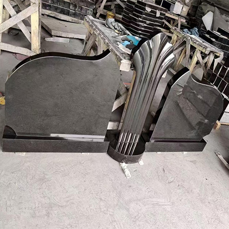 "Polished black granite headstone with fluted crest and vertical grooves, produced at Elhasg factory."