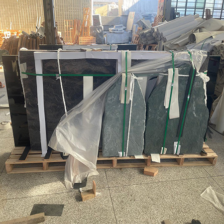 "Granite headstones and ledger covers strapped and padded on pallet in Elhasg warehouse."