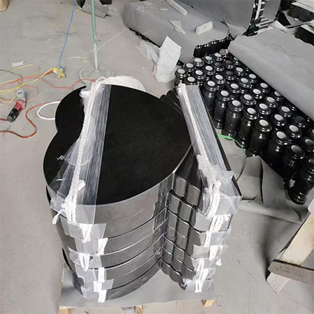 "Bundled heart-shaped polished granite slabs on pallet at Elhasg workshop, prepared for memorial installation."