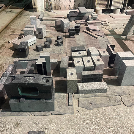 "Granite blocks and surface plates arranged for Japanese headstone preparation in Elhasg workshop with tools and crates."