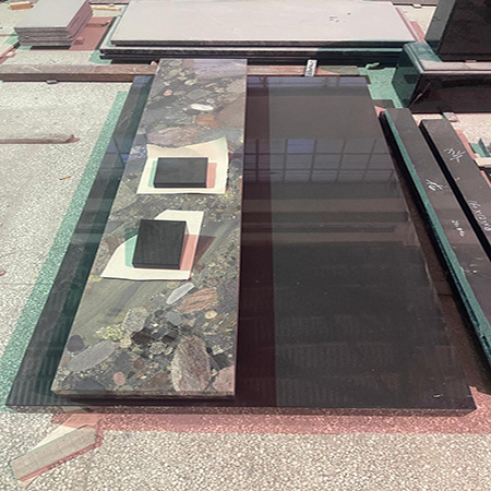 "Ledger tombstone cove with terrazzo centerpiece and polished granite slabs, arranged at Elhasg."